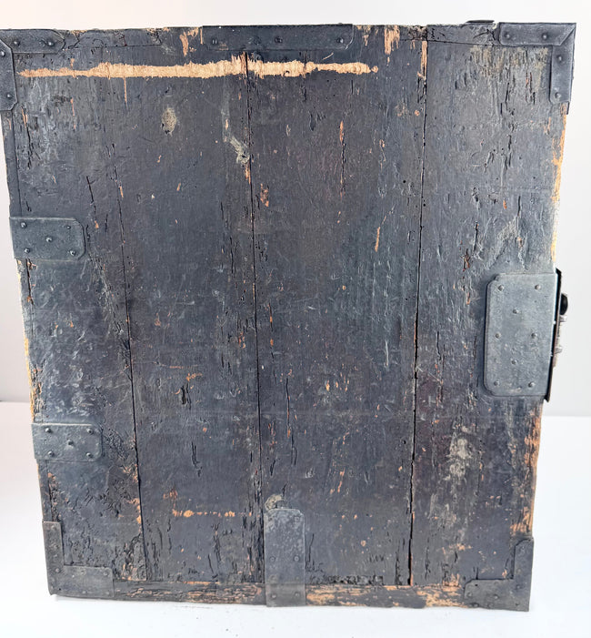 Side view of antique funa tansu displaying iron reinforcement bands, aged wood surface and maritime chest construction