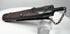 Angled rear view of antique Japanese gunpowder flask showing suspension clip, textured lacquered body and metal fittings