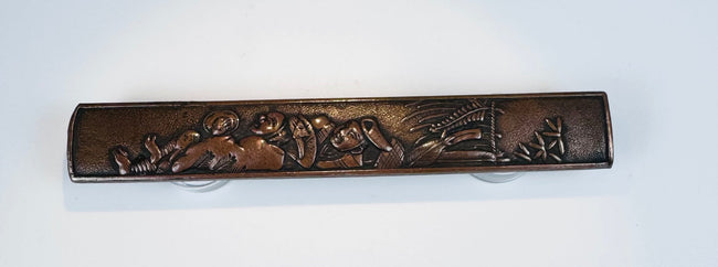 Japanese copper-alloy kozuka handle with raised Four Sleepers figural decoration