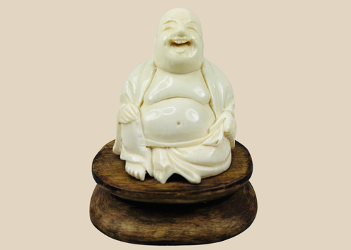 Antique Laughing Buddha bone carving seated on wooden stand, late 19th century