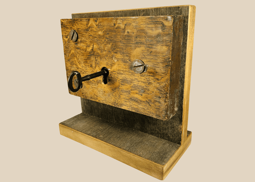Antique mortise door lock with skeleton key mounted on wooden display