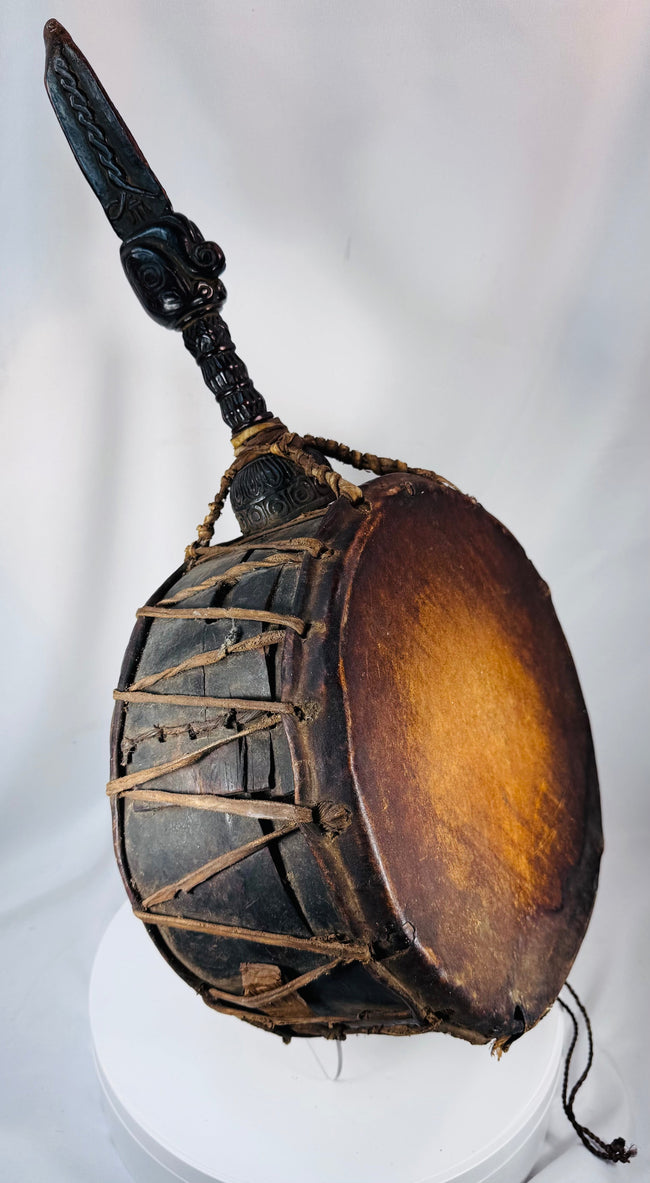 Himalayan shaman's drum from Nepal displaying extensive rawhide bindings and traditional ceremonial craftsmanship.
