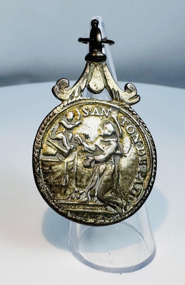 Close-up view of an 18th–19th century Catholic devotional medal featuring Saint Anthony of Padua.