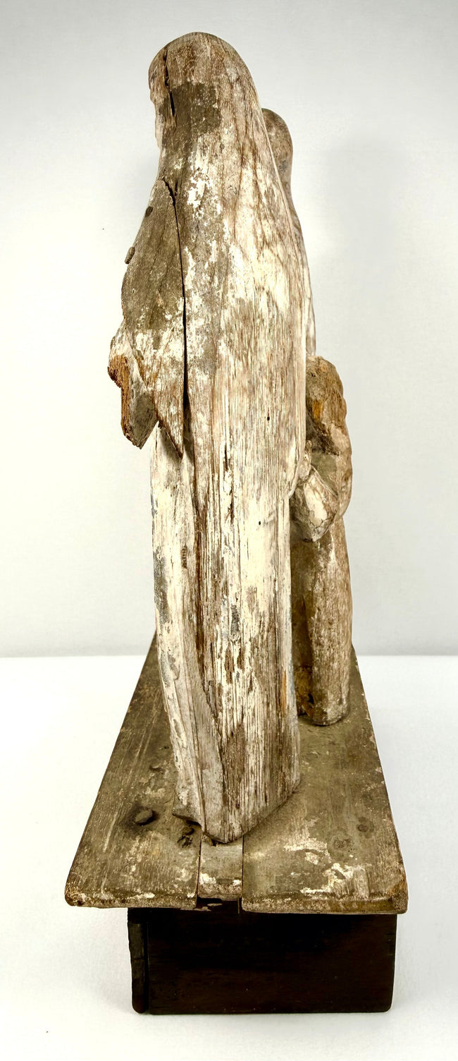 Rear view of wooden Santo figures revealing deep timber cracks and flaking paint layers