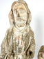 Close-up of weathered hand-carved wood Santo figure with faded white paint and natural patina