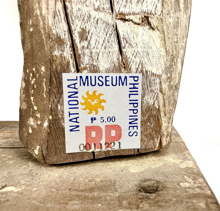 Close-up of National Museum Philippines authenticity sticker on rough antique wood surface