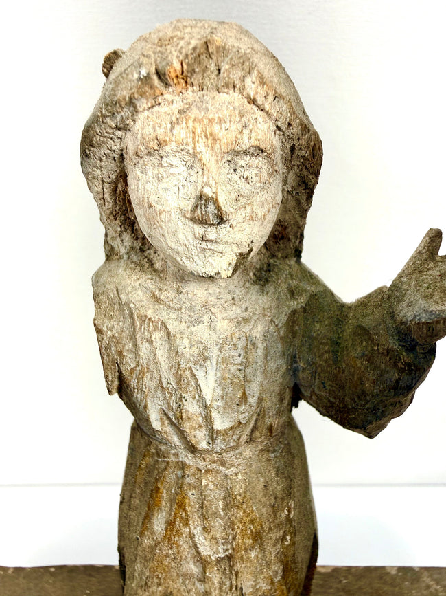 Detail portrait of small central child Jesus figure with simplified features and chipped paint