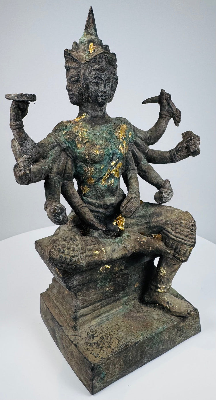 Opposite side view of the Thai devotional statue with raised ritual objects