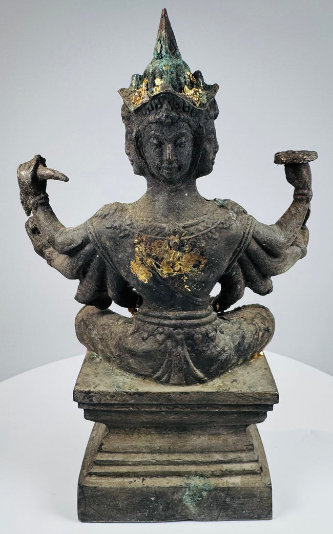 Rear three-quarter view showing the four faces and elaborate pointed headdress