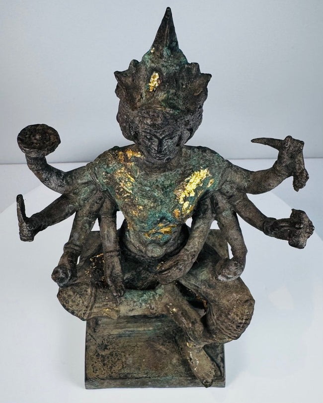 Close front view of the four-faced Brahma statue with surviving gold leaf