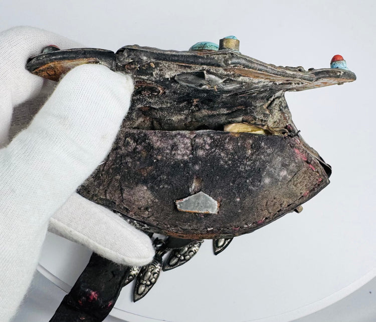 Historic Himalayan ceremonial pendant with silvered copper construction, coral inlays, and original textile strap.
