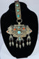 Traditional Himalayan gau amulet case featuring repoussé metalwork, turquoise inlay, and suspended pendant drops.