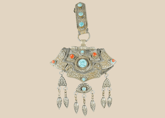 Antique Tibetan gau portable shrine pendant crafted from silvered copper alloy with turquoise and coral cabochons.