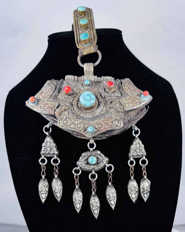 Historic Tibetan Buddhist portable shrine decorated with repoussé floral motifs and turquoise cabochons.