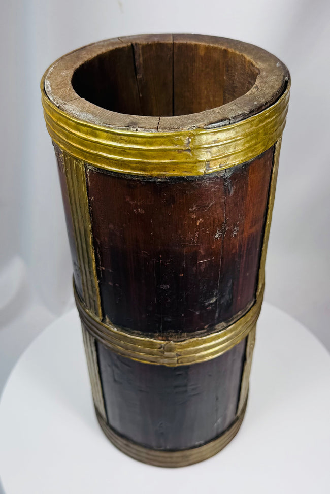 Traditional Tibetan grain container featuring dark hardwood staves and hand-worked brass reinforcements.