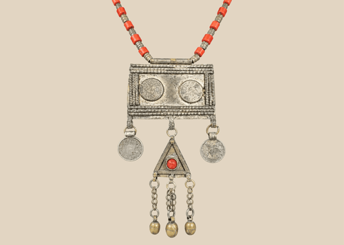Antique Turkmen tribal necklace with a rectangular pectoral pendant, tumar amulet, and red glass beads.