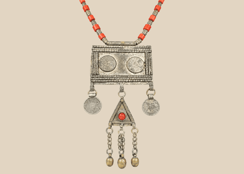 Antique Turkmen tribal necklace with a rectangular pectoral pendant, tumar amulet, and red glass beads.