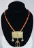 Historic Turkmen tribal necklace displaying traditional Central Asian jewelry with coin elements, red glass accents, and ornate metalwork.