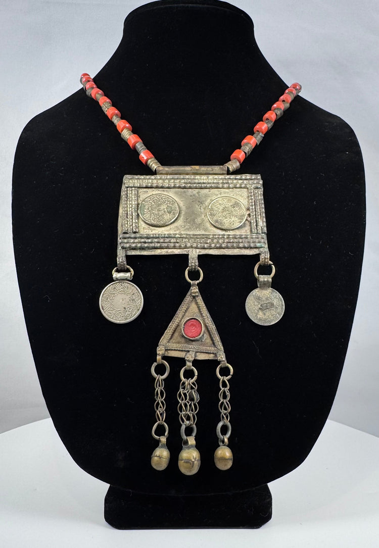 Antique Turkmen tribal jewelry with suspended coin elements, red glass beads, and handcrafted silver-toned metalwork.