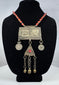Antique Turkmen tribal jewelry with suspended coin elements, red glass beads, and handcrafted silver-toned metalwork.