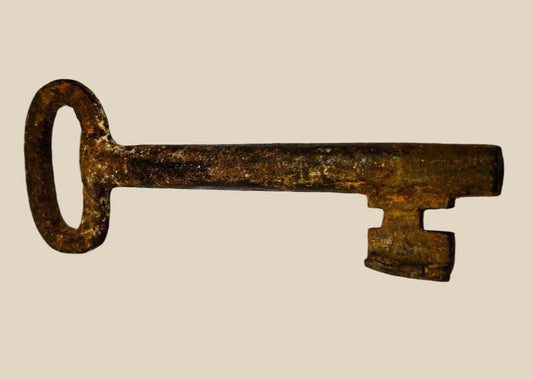 18th-century European forged iron skeleton key with oval bow, wedge-shaped ward, and developed patina, used for warded locks in manors, castles, or estates.