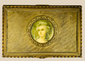Antique gold decorative box featuring a painted portrait miniature of a woman displayed on a beige background.