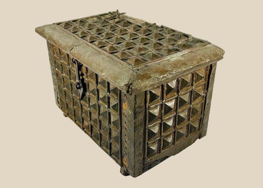 Late 19th-century Indian lidded box made of hardwood with brass cladding, featuring embossed geometric and pyramid-like designs. Original lock and latch intact. Combines traditional Indian craftsmanship, functional storage, and decorative elegance.