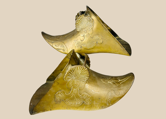 Pair of antique brass Spanish Colonial slipper stirrups with ornate figural relief decoration.