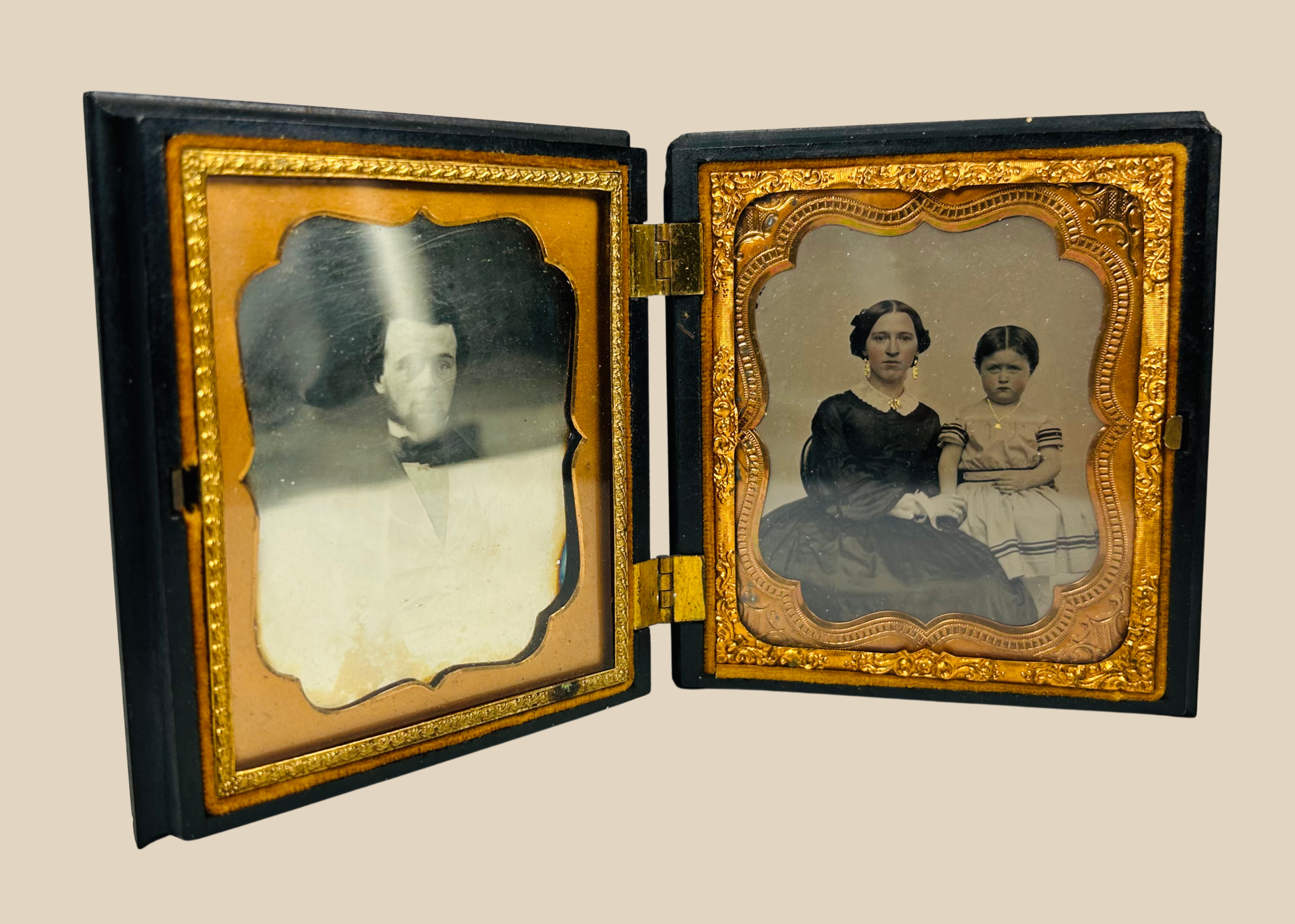 Antique Victorian daguerreotype case opened to reveal two 19th-century portraits