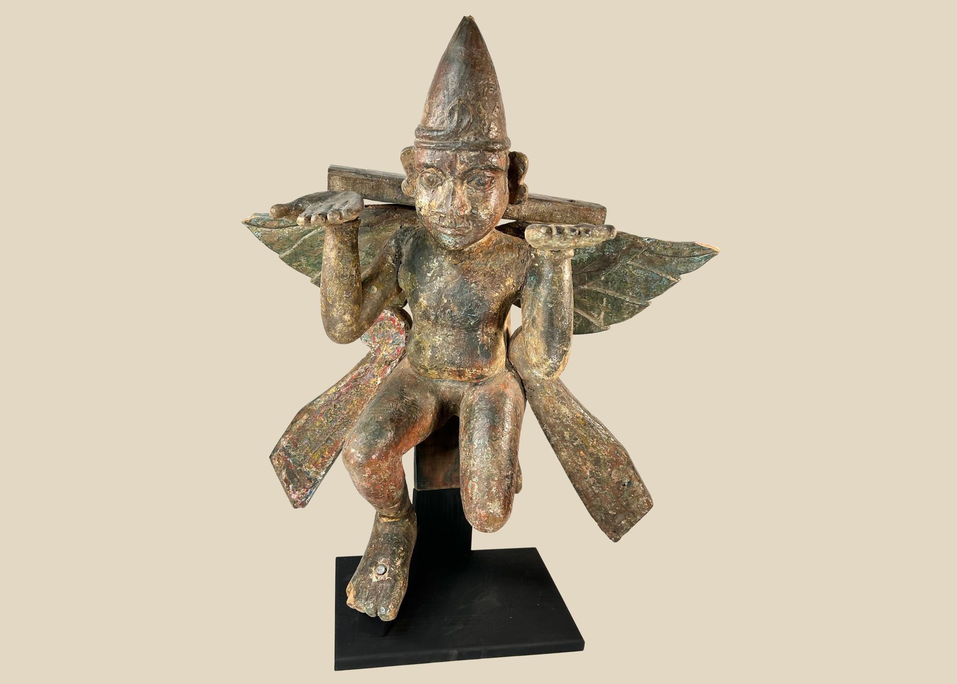 Antique hand-carved wooden winged temple guardian figure on display against a white background.