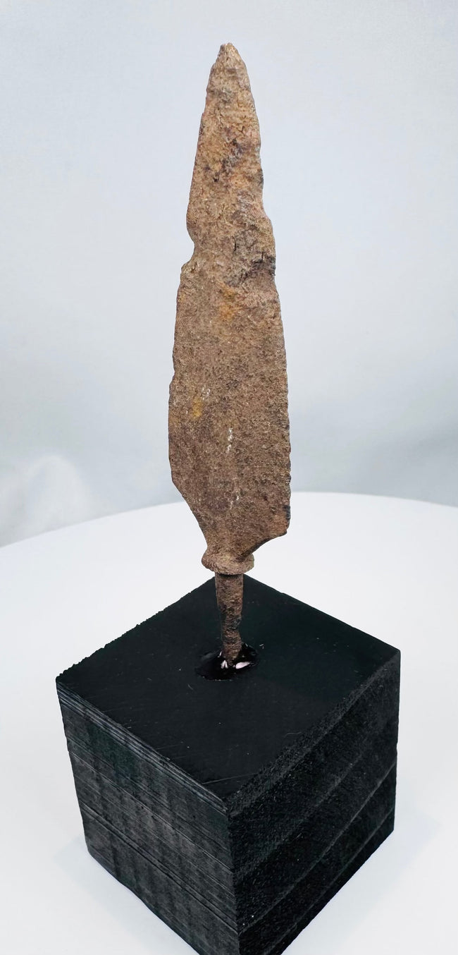 Broad tanged iron weapon point with heavy oxidation and mineral encrustation