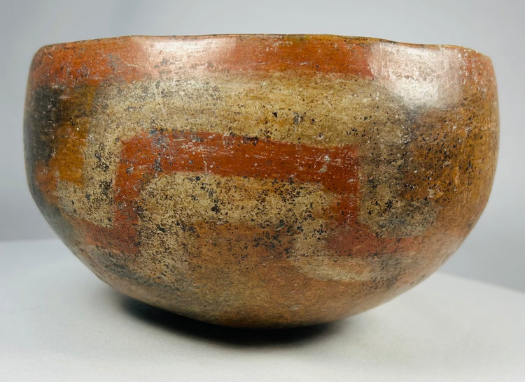 Ancient Mesoamerican hemispherical terracotta bowl with earth-tone pigments