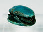 Three-quarter angled view of ancient Egyptian scarab with vivid blue-green glaze patina