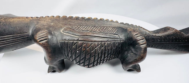 Close-up of carved Malian crocodile head with inserted teeth and geometric decoration