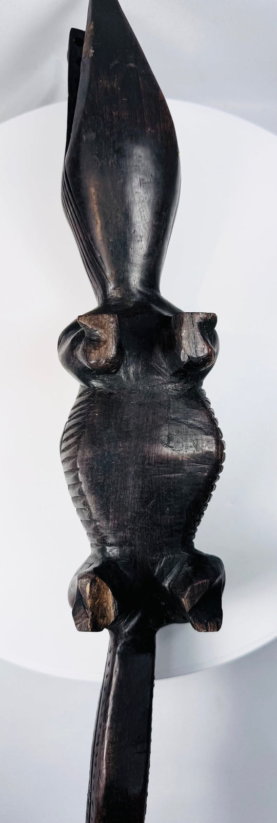 Side view of elongated Malian crocodile carving with segmented tail and carved legs