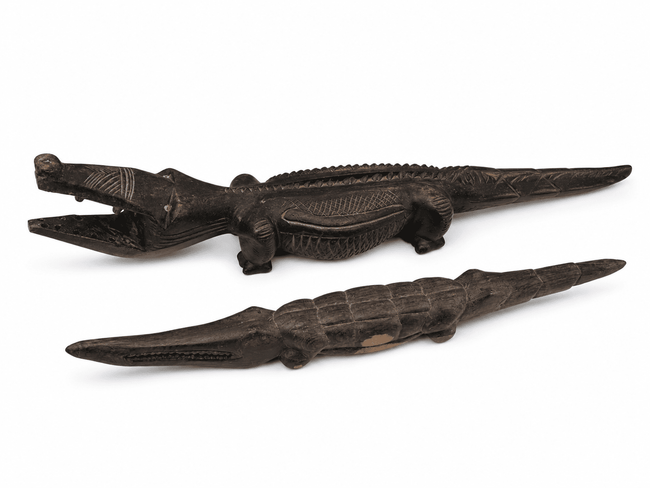 Malian hand-carved wood crocodiles with elongated bodies and dark aged surfaces