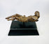 Three-quarter view of a European carved wooden Christ figure displayed horizontally on a modern black stand