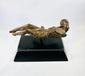 Three-quarter view of a European carved wooden Christ figure displayed horizontally on a modern black stand