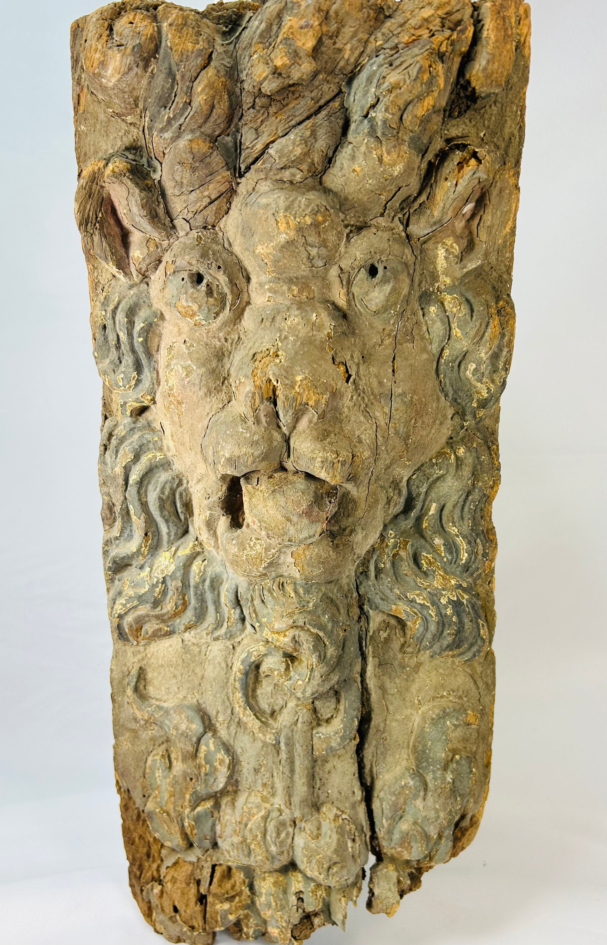 Hand-carved hardwood Baroque lion mascaron corbel with swirling mane, traces of original blue-grey paint, gesso, and parcel gilding, integral tenon and fixing holes for architectural mounting, late 17th–early 18th century, Europe, circa 1650–1750.