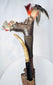 Close-up of Dayak Mandau hilt with Aso carving, feathers, hair, and fibre wrapping