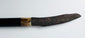 Mandau sword displayed beside its carved scabbard and attached pisau raut