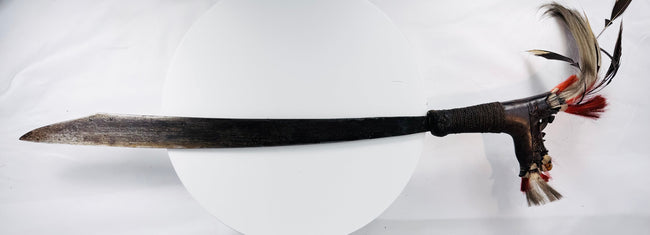 Lower scabbard detail with hair, feathers, carved pendants, and darkened patina