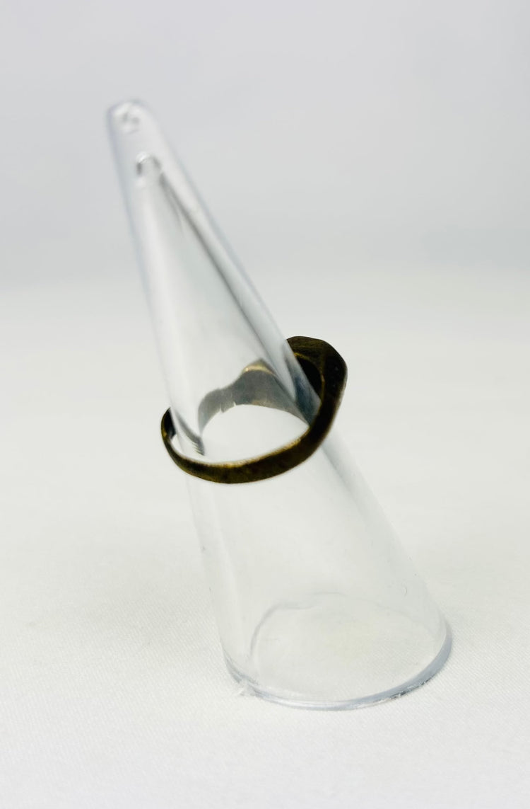 Ancient metal ring with incised geometric design on stand