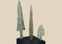 Three ancient Western Asiatic bronze projectile points mounted on a black display base