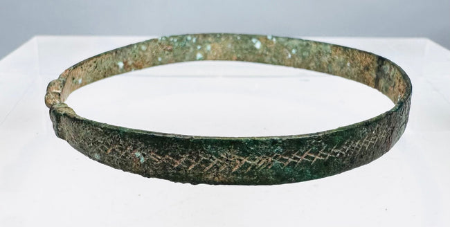 Penannular bronze armlet decorated with hatched bands, pointillé triangles, and annulets