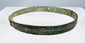 Penannular bronze armlet decorated with hatched bands, pointillé triangles, and annulets