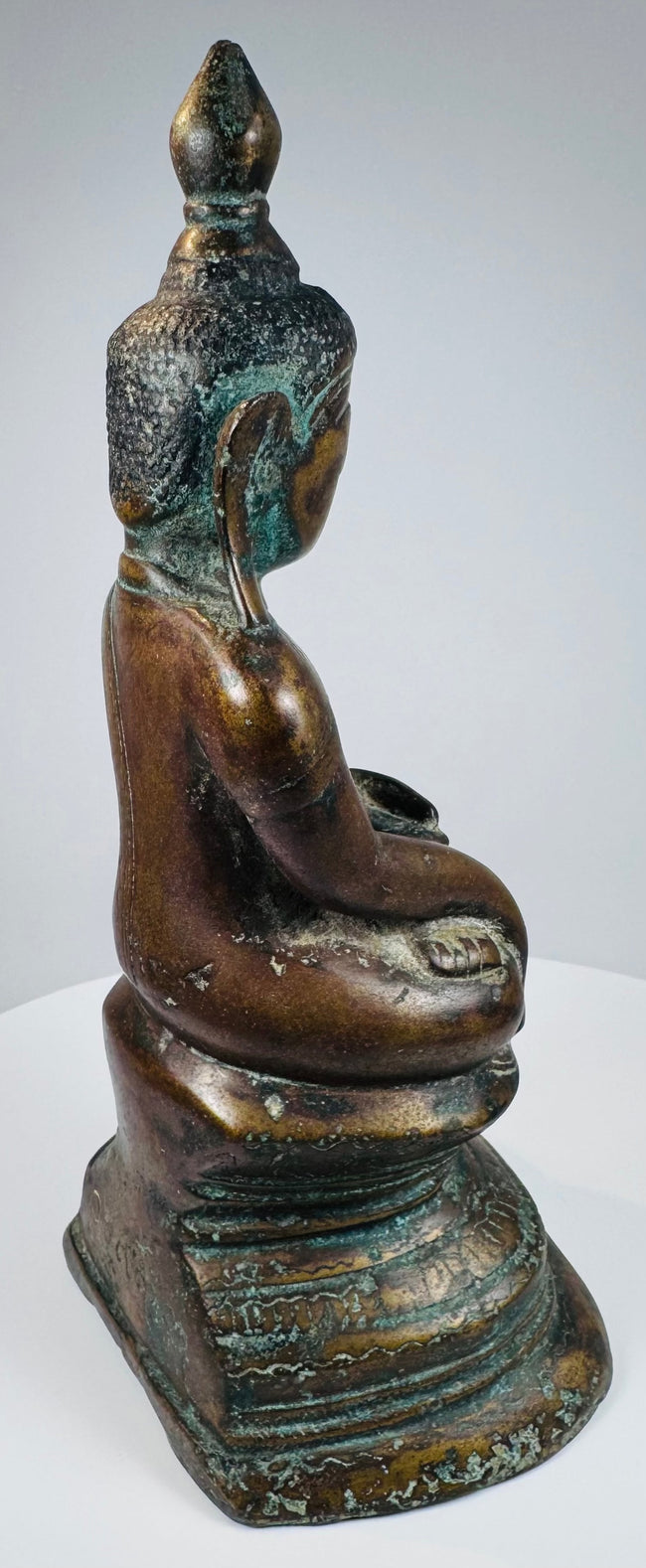 Rear three-quarter view of the Konbaung Buddha with green verdigris patina