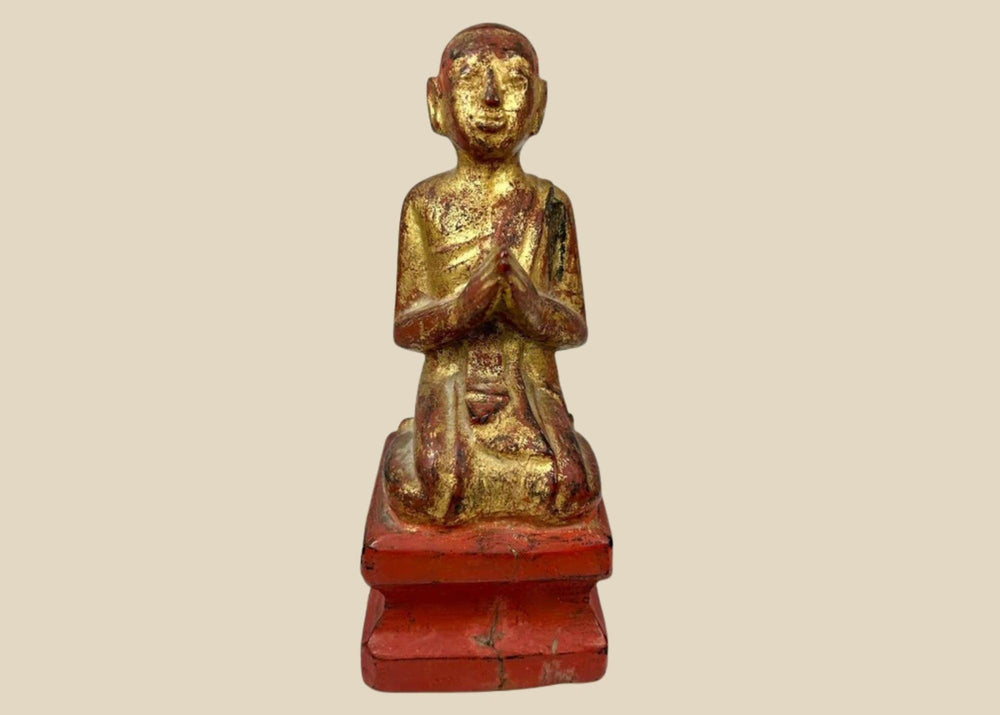 Hand-carved Burmese wooden monk statue, 18th–19th century, with gold leaf and red lacquer, kneeling in prayerful devotion.