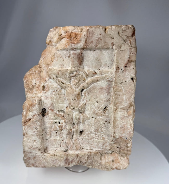 Historic European stone architectural fragment with relief carving of the Crucifixion and surrounding structures