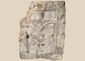 Medieval carved stone fragment depicting Christ on the Cross within an architectural niche with surrounding relief details